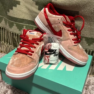 Nike sb dunk low x Strange Love  - Ett par helt nya och oanvända Sb dunks. Två par extra skosnören medföljer. Skriv för fler bilder och info. Svarar gärna på alla frågor.