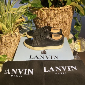 Lanvin Cap Toe Sneaker Nappa Black - Hej, säljer ett par Lanvin Cap Toe Sneakers i svart läder. Size 5=40/40,5. Använt skick, bild på slitningar i DM. Dustbag medkommer. Nypris 4400kr. Neutral färg & passar till allt. Bekväma & görs ej längre. Pris kan diskuteras. Hör av dig vid frågor. 