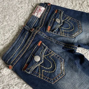 Vintage True Religion jeans - FRI FRAKT! 🥰 Världens snyggaste trueys med lågmidjad bootcut modell och coola detaljer. ❤️ Innerben: 80cm, midja rakt över: 35cm. Jag är 165cm som referens, kan fixa fler mått! 🫶 Håll koll på min profil, lägger för det mesta upp vintage jeans. 😍
