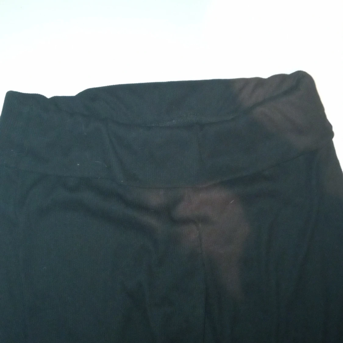 Svarta utsvängda byxor som är vikna