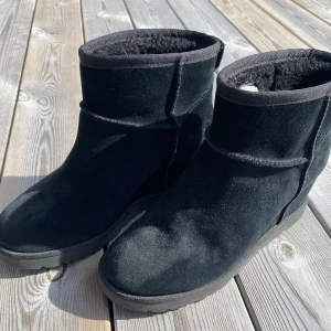 Uggs  - Ugg, Classic Femme, Mini boots med dåld kilklack i färgen svart. De är i bra skick. Köpte de för 1990kr 