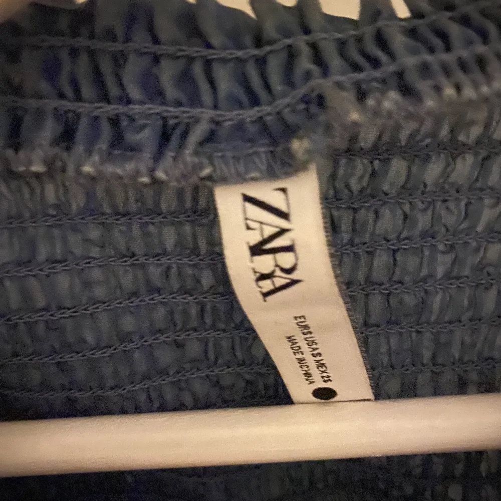 Topp från Zara i denimfärg i strl S. Normal i storlek. Använd max 2-3 gånger, så den är som ny. Nypris var 399:-. Blusar.