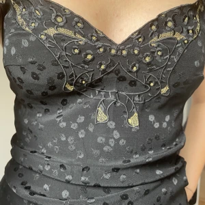 Lucie Lindén fest topp - Jättefin topp köpt secondhand med guldiga detaljer insydda, väldigt fin passform i ett najs material. 