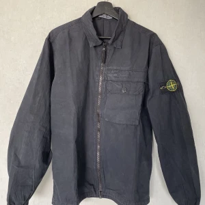 Stone island jacka - Säljer en stone island jacka i färgen marinblå. Nypris 3600 och i väldig bra skick 10/10. Storlek L men är liten i pass formen så passar även  M också. 