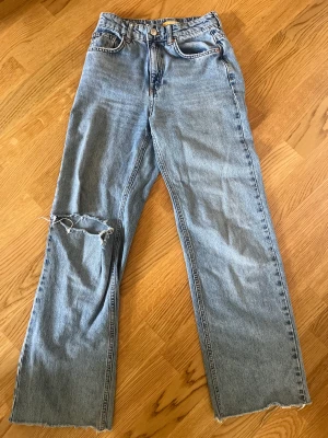 Jeans  - Blå jeans med ett hål i knät. Köpt på Gina tricot 