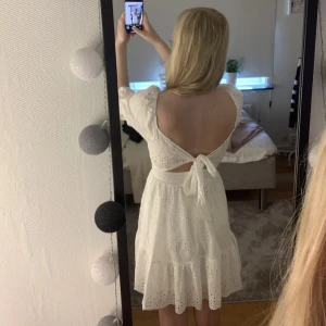 Broderad klänning - Jättesöt broderad klänning som aldrig är använd! Dragkedja baktill och en jättefin knytning i ryggen. Något liten i storleken! Perfekt till studenten eller en sommarkväll! Köparen står för frakten🩷