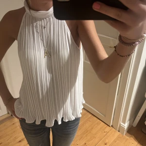 Vit halternecktopp - Halterneck från zara som inte säljs längre. Plizzerat material som känns så lyxigt! 
