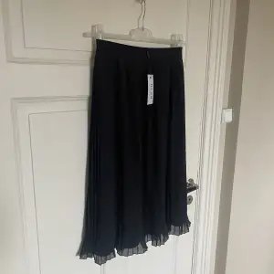 Säljer denna snygga plisserade kjol från NA-KD. Helt ny och lappen sitter kvar. Storlek 34. Resårband. 