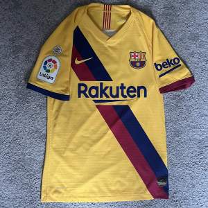 FC Barcelonas bortatröja under 2019/2020 säsongen. Tröjan är i 10/10 skick och såklart äkta. Nypris ligger på runt 1600 kr i och med att det är Vaporkit, vilket är den varianten spelarna har på sig. LaLiga Champions patch finns även på höger ärmen. 