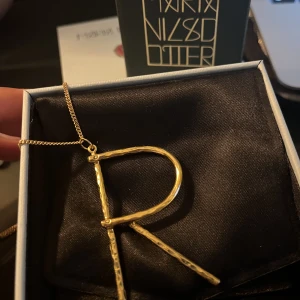 Maria Nilsdotter Wonky letter  - Säljer mitt fina Maria Nilsdotter halsband, wonky letter i den stora modellen. köpt för 2995💛Säljer endast berlocken.  Kan tänka mig byta till silver eller något i samma prisklass ❤️‍🔥