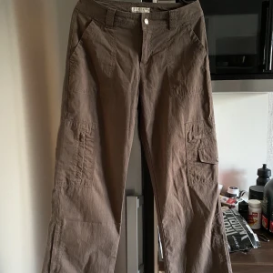 Cargo byxor bruna  - Bruna cargo byxor från NET international. Fint skick skulle säga 8/10.  Slits på sidorna av benen, fickor längst benen och i bak.   Ca 38 cm i midjan  Köpt på second hand 