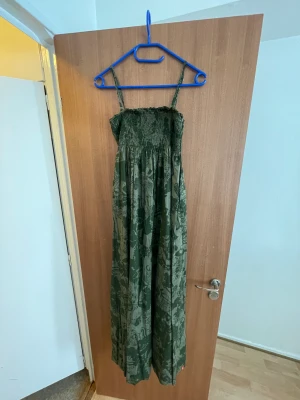 Long green dress - Long flowy green dress with dark green pattern. Elastic material around chest. Good condition.