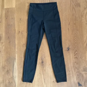 Svarta träningstights - Svarta träningstights från Soc. Coola sömmar som går längs benen. Bra skick. Storlek: M. Inköpspris: 375 kr. 