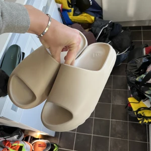 Yeezy slides - Hej säljer nu mina yeezy slides då jag inte idnavänder dom, andvända ett fåtal gånger. 100% äkta box följer med.  Priset kan diskuteras vid en snabb affär