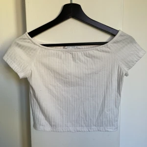 Vit ribbad t-shirt - Använd en gång. Off shoulder men kan även ha uppe på axlarna.