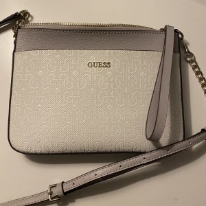 Guess väska  - Vit/grå Guess väska med silver detaljer, går även att ha som clutch.  Använd endast några gånger 🩵