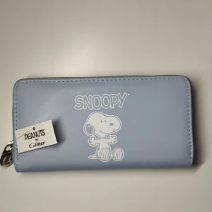Plånbok  - Säljer denna oanvända plånbok ifrån peanuts by glitter kollektionen. Går ej att köpas nu, säljer pga att jag inte använder den💕 nypris: 150 säljer för 80kr💕