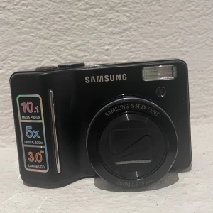 Digitalkamera  - Samsung digitalkamera i fint skick, finns några små repor som knappt är synliga! Går på två AA batterier. Väska och minneskort medföljer! Skriv för fler bilder! 