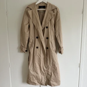 Trenchcoat - Fin trenchcoat med knappar och band, använd en gång så i nyskick. 100 kr exkl frakt. 