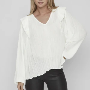 Vit blus från VILA - Säljer denna supersöta blus med volang från VILA i storlek 36. Köptes i Stockholm nu i somras och har inte använt den särskilt mycket så den är fortfarande i nyskick :) nypris är 450kr och jag säljer för 180kr och då är frakt inräknat i priset ☺️💕