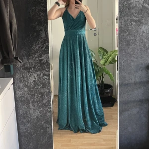 Balklänning - Säljer min glittriga balklänning som är så gott som ny, hade den på min vinterbalen för ett halvårsrdan. Passade perfekt till temat och var jättefin på bilderna🥰. Jag är 165 cm och hade 5 cm klackar på balen då passade den perfekt för mig i längden. 