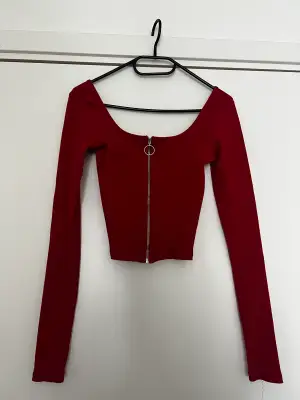 En röd hollister tröja med öppen urringning och dragkedja i fram