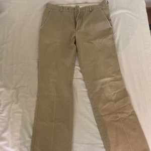 Beiga chinos - Beiga chinos. Ganska använda men bra skick. Lite åt Dickies hållet. 28 i midjan och 30 i längd