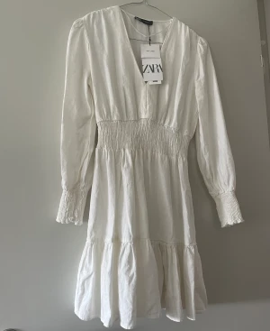 Linne klänning helt ny - Fin vit linneklänning från Zara. Helt oanvänd. Längd 82-83 Ärmlängd 56