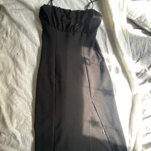 En svart klänning med slit vid benet 