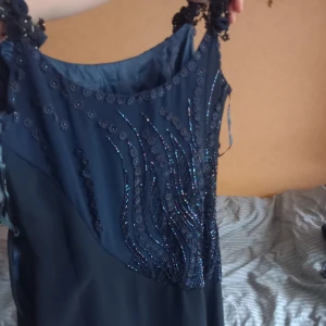 Aftonklänning - Jättefin aftonklänning med många vackra detaljer. Inga synlifa defekter och i mycket gott skick! 