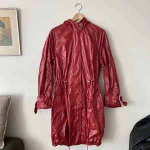 Regnjacka Tiger of Sweden - Regnjacka från Tiger of Sweden. Luva bak och dragsko i midjan samt nertill. Knäpps med dragkedja. Superfint skick, hittar inget att anmärka på. Strl 38 men passar även mindre (jag har vanligtvis 34-36).