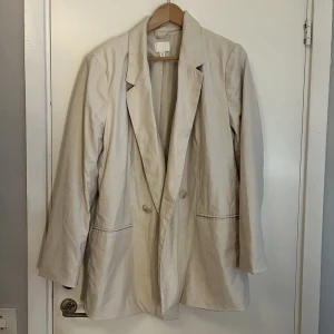Blazer - Beige blazer från Hm, den är inte strykt på bilden, stryker innan den köps.