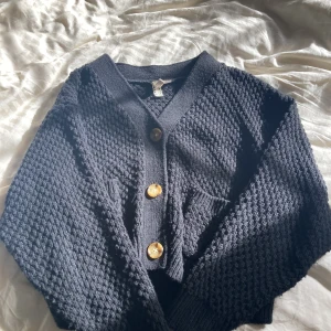 Kofta - Kofta med bruna knappar. Stickad