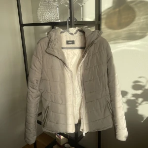 Vinterjacka - En beige vinterjacka från ONLY. Fuskpälsen på luvan är avtagbar så du kan själv välja om du vill ha med eller utan. 