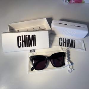 Svarta solglasögon från CHiMi i toppskick, modell #005 i färgen berry. Levereras med originalförpackningen innehållandes deras mjuka och skyddande CHiMi-tygpåse, hårda fodral, samt putsduk (oöppnad). Köpta för ca 1000kr 2018. Säljer pga använder sällan. 
