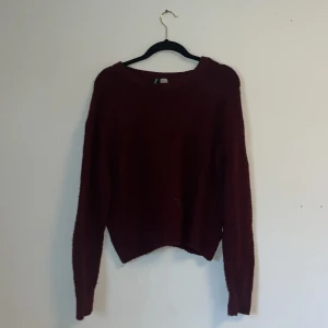 Stickad röd tröja - En röd stickad tröja utan tecken på användning. Något nopprig men inte tydligt alls