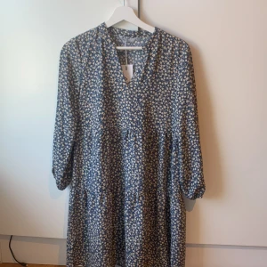 Blommig klänning - Kort klänning som aldrig använts. Är i flowigt och lätt material.