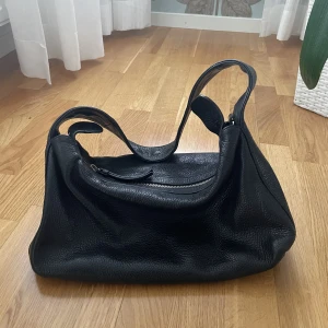 Svart väska i läder - Väska i äkta läder från & other stories med nypris 1500kr. Jättebra kvalitet då jag använt den i ett år och den fortfarande är som ny. Har massa fler bilder hur den sitter på så det är bara att skriva. Priset kan diskuteras❤️