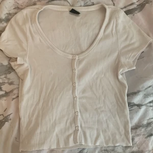 Fin sommartop! - Här är en fin tröja som man kan ha på sommaren. Knappar hela vägen ner. Storlek M!