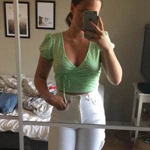 Grön topp med knyt - FRI FRAKT IDAG från klockan 18! Grön fin topp med små vita blommor och omlottknytning. Använd 1/2 gånger, säljer pga för liten nu. 