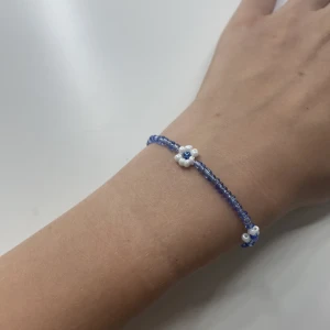 Blått pärlarmband  - Ett blåblomigt pärlarmband i storlek s men finns i fler storlekar om man vill ha kontakta om de uppstår frågetecknen!💙