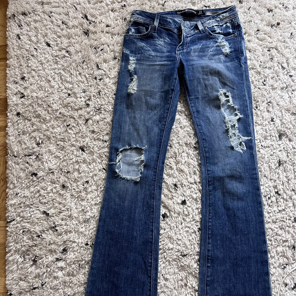 Lågmidjade jeans med större hål, köpta secondhand. Fint skick med knappen vid dragkedjan är borta.. Jeans & Byxor.