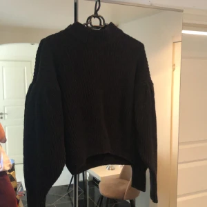 Stickad tröja  - En snygg svart tjockt stickad tröja med puffiga ärmar. 