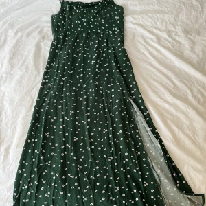 American Eagle långklänning - Mörkgrön fin klänning med blommor från American Eagle i stl S. 💚 Den slutar ungefär vid ankeln på mig. (Är 165cm) Har en slits vid ena benet. Använd några gånger.    