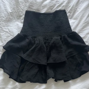 Volangkjol - Svart Volangkjol i storlek xs, passar nog även s eller m då den är väldigt stretchig. säljer då den inte aldrig kommit till användning😊 40cm i längd 