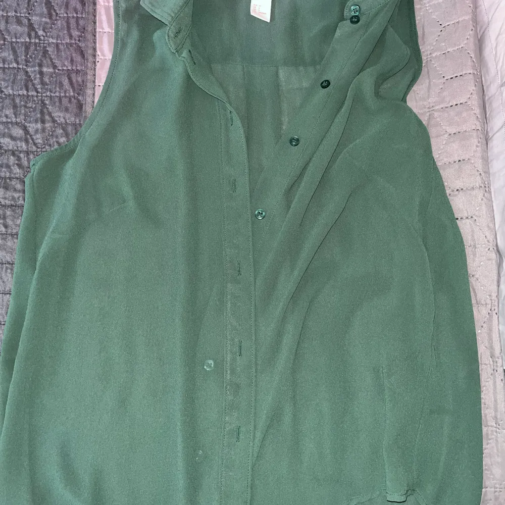Grön skjorta utan armar. Lätt tyg till sommaren. Köpt från H&M. Sparsamt använd. . Skjortor.
