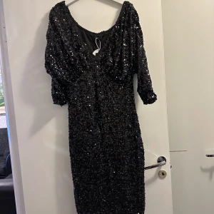 Svart glittrig klänning - Svart glittrig klänning med prislapp, oanvänd alltså. Storlek L, köpt på boohoo. Skriv för mer bilder, pris 600kr