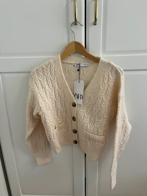 Ljus stickad kofta - jättefin och mysig kofta från zara med tre knappar. stickad och cropped.