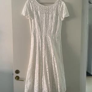 Vit spetsklänning - Vit klänning. Använd 1 gång. Är för liten nu och säljer därför. Dragkedja i rygg och korta ärmar. Når ungefär ner till knäna (jag är 168 cm lång) 