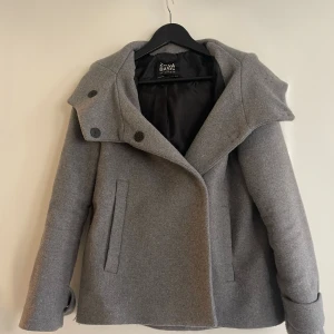 Kort Kappa ZARA - En kort grå kappa från zara. Något tjockare material som funkar jättebra på våren, hösten och tidig vinter! 
